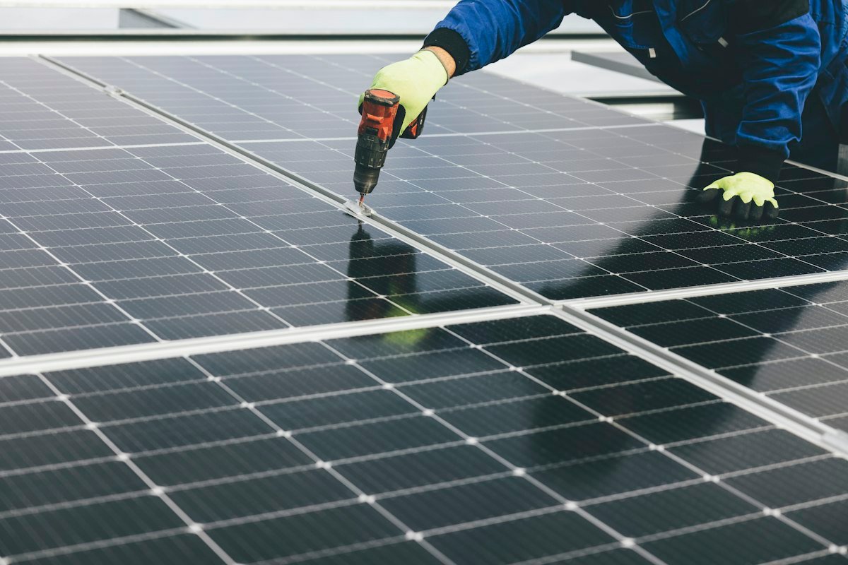 Worker fastening solar panels on a commercial rooftop